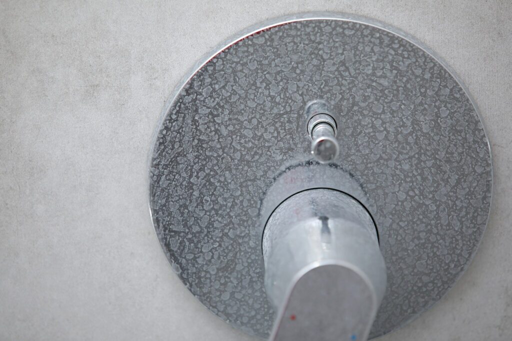 Dirty shower faucet with limescale on it