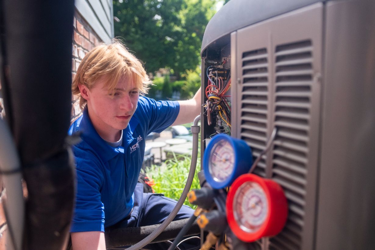 AC technician repairing an outdoor AC unit.