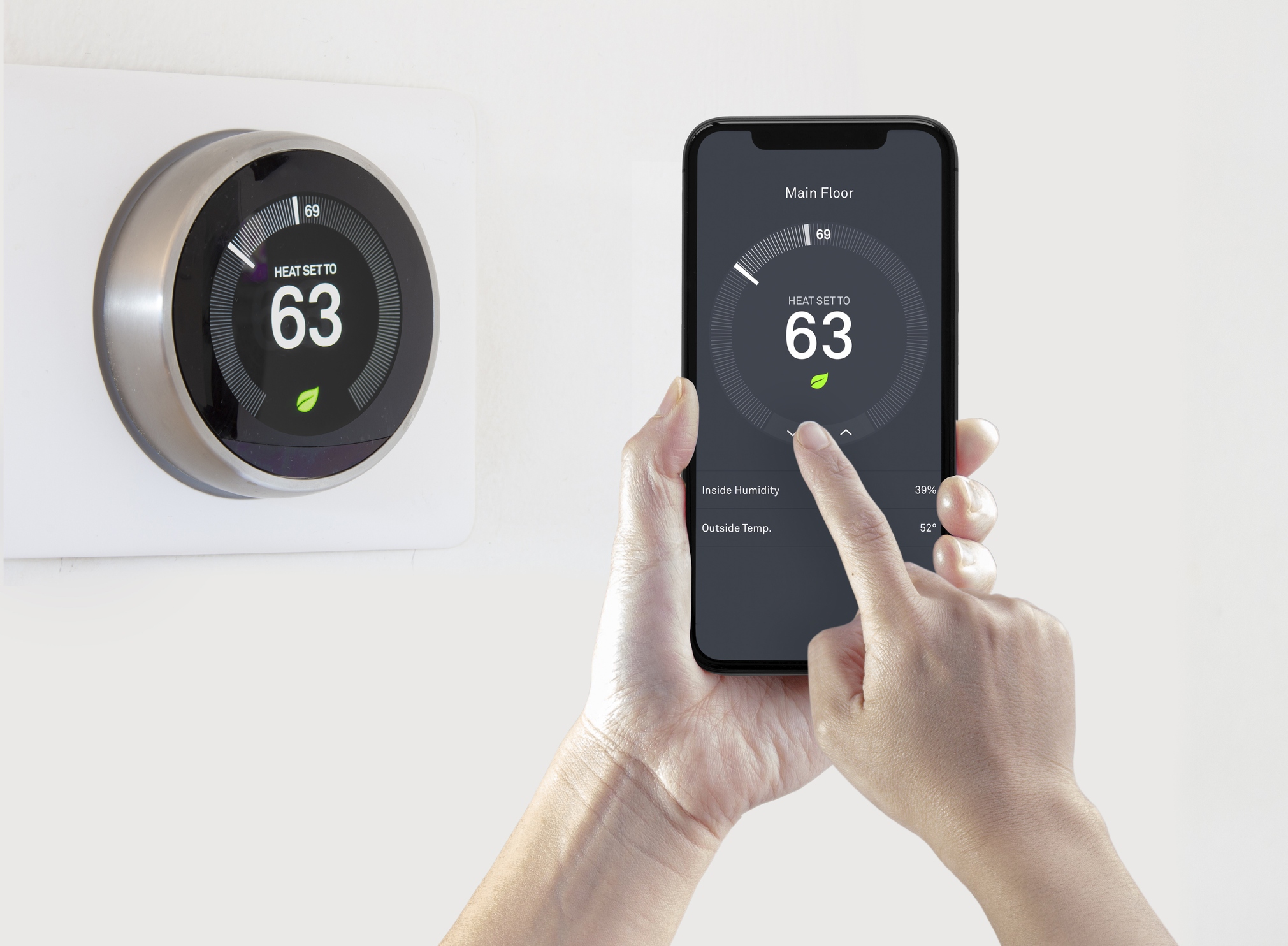 A person using a smart phone application saving energy with a wireless smart thermostat 