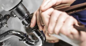 hands performing plumbing repair