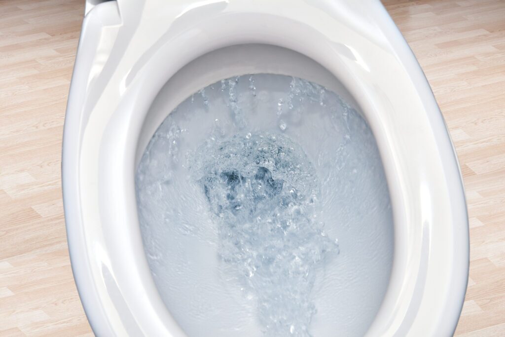 Close up of toilet bowl  flushing water in bathroom