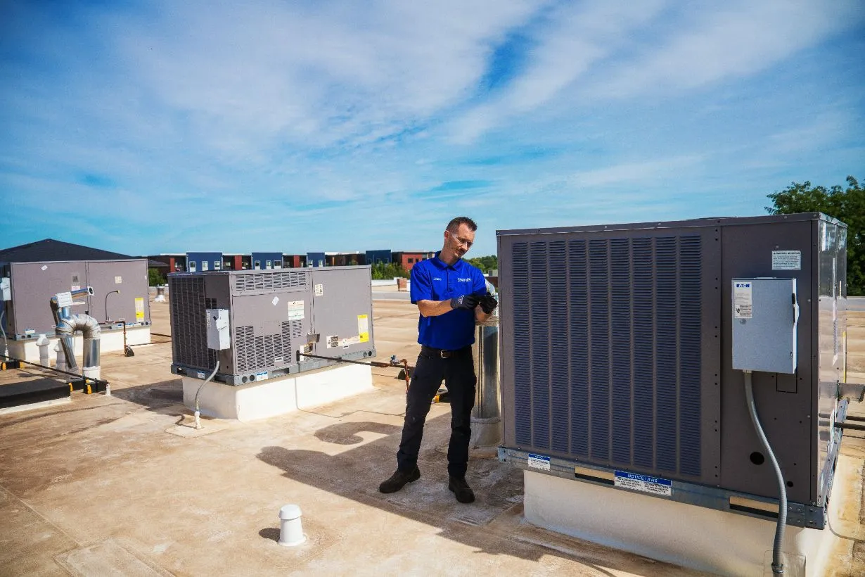 HVAC tech checking a commercial mini split air conditioner amps with a meter