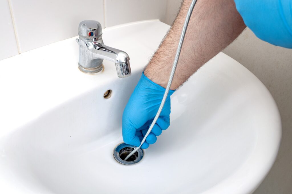 using an auger to clean a sink drain